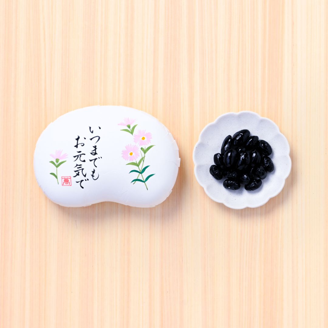 北の大地の黒豆甘納豆（豆箱入り）　絵柄：いつまでもお元気で撫子(▼まめや金澤萬久紙袋（ＳＳ）付き)